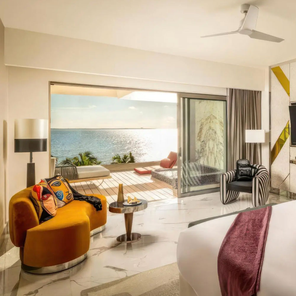 Viginti XX armchair with striped black and white fabric at Hotel Mousai, next to a beach view window.