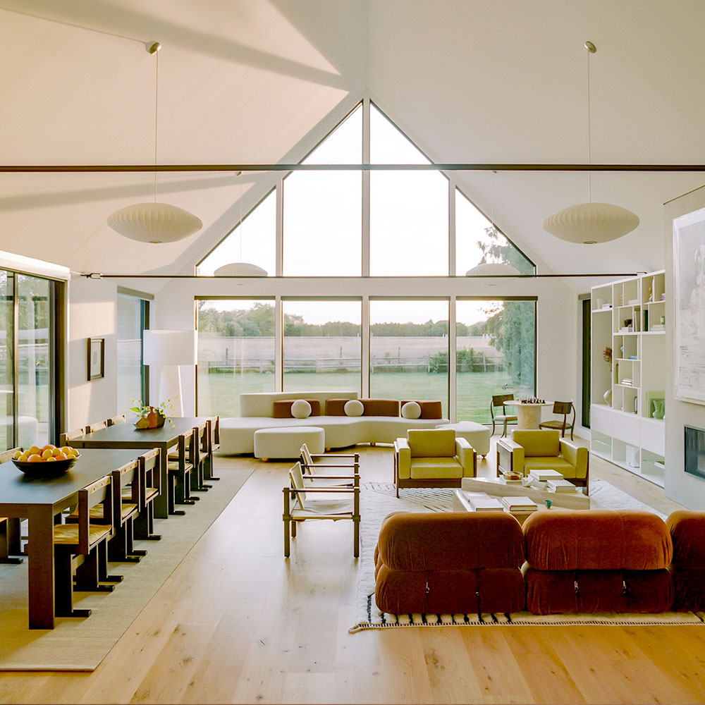 Mood sofa in cream color with dark orange pillows at South Hampton Farmhouse.