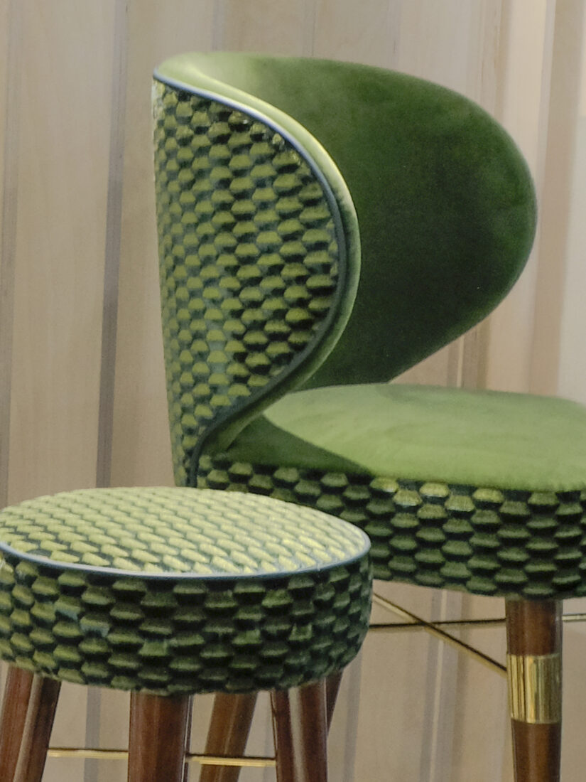 Louis Bar Stool and Louis Bar Chai Louis Bar Stool and Louis Bar Chair, both upholstered in green patterned fabric with smoked walnut wood structures and brushed brass accents