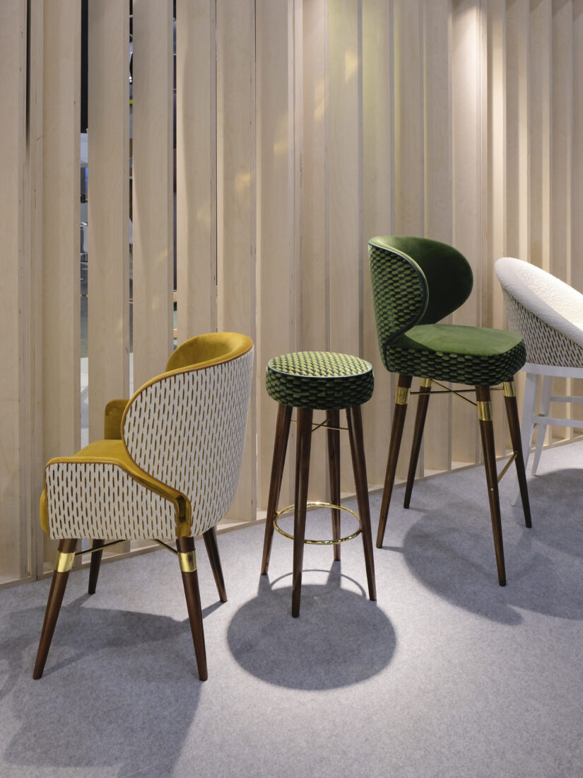 Louis I dining chair, Louis Bar chair and Louis Bar Chair Louis I Dining Chair upholstered in yellow fabric with a white back, featuring a smoked walnut wood structure and brushed brass details, next to a Louis Bar Stool in matching materials with green patterned fabric, and a Louis Bar Chair