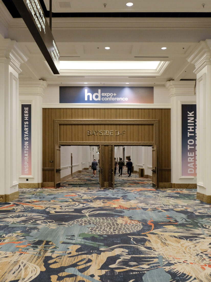 HD Expo 2025 Entrance to the HD Expo 2025 featuring a patterned rug and double wooden doors with a decorative frame.