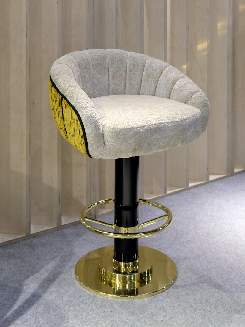 Vivien Swivel Bar Chair Vivien Swivel Bar Chair upholstered in fur-like beige fabric with a yellow back, black lacquered leg, and polished brass accents