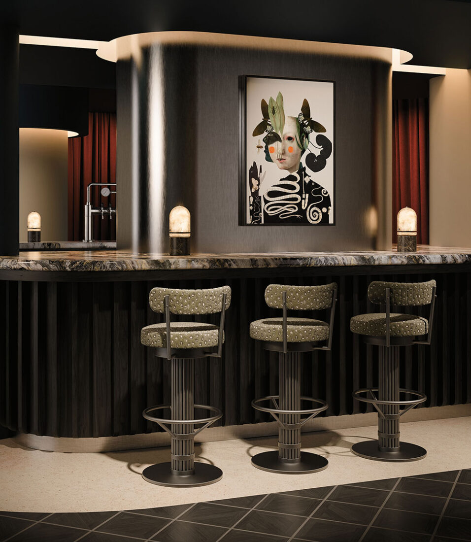 Bar setting by Porus featuring the Willis Bar Chair upholstered in luxurious patterned green fabric, accompanied by the Russell Table Lamp with marble and alabaster.