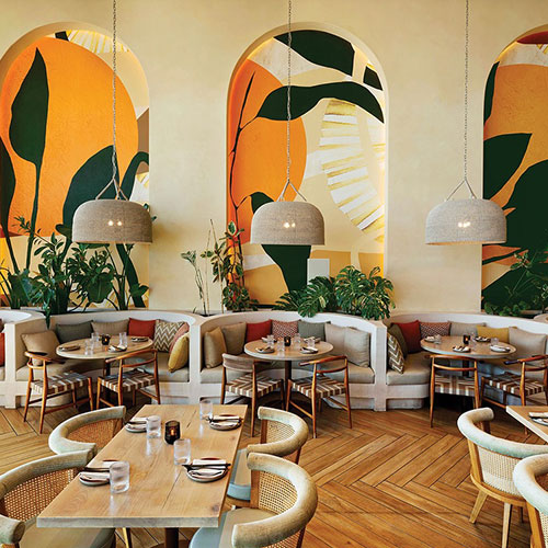 Dining area at Planta restaurant with varied seating arrangements, featuring the George Dining Chair in oak with natural rattan.